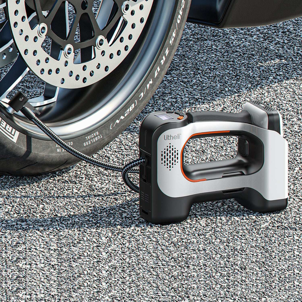 Cordless tire inflator pumping car tire on the road, portable air compressor for emergency use